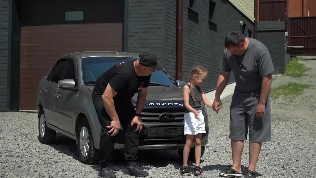 Александр с семьёй рядом с полученной Lada Granta и ведущим Garage 54